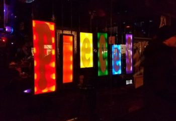 Pieces Bar in New York: Colorful sign at this popular gay bar. A nightlife hotspot with a fun, friendly atmosphere. Gay travel advice.