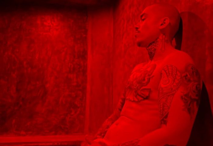 Tattooed man in red light at Piñata PV Gay Hotel. This gay hotel in Puerto Vallarta offers a unique experience for gay travelers.