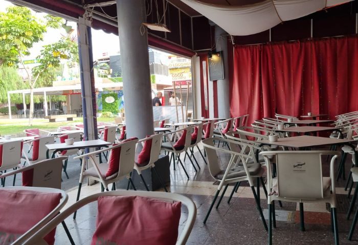 Pirates Bar, Gran Canaria gay bar outdoor seating area. Tables and chairs with red accents, offering a relaxed vibe for gay travelers.
