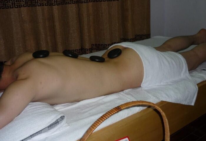 Man getting a hot stone massage at Polar Spa in Hanoi. Gay travel advice for relaxation and pampering.