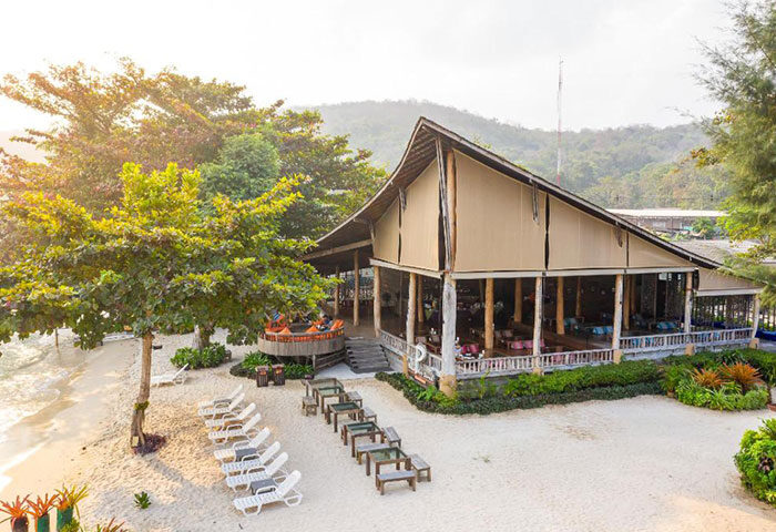 Baan Ploy Sea, a popular beachfront gay hotel in Koh Samet. Beach view with sun loungers and outdoor dining. A quiet, relaxing gay vacation spot.