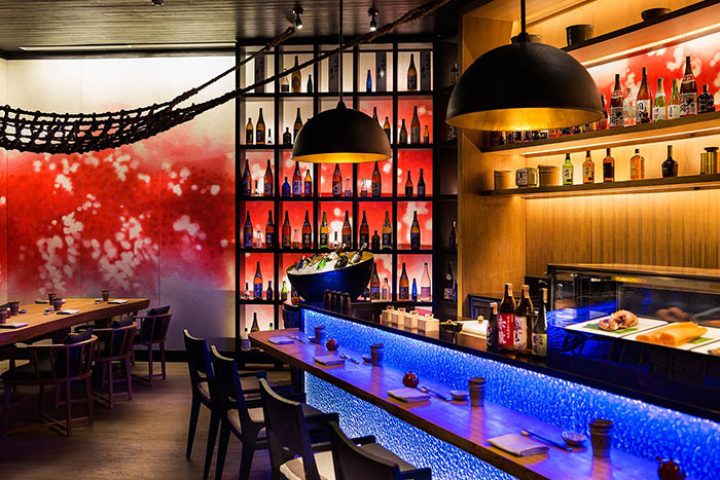 LUX* South Ari Atoll, Maldives gay beach hotel. Sushi bar interior with blue lighting, sake bottles, and modern design elements. Upscale dining.