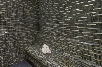 JW Marriott Hotel Istanbul Marmara Sea hamam. Mosaic tiled steam room with towels and shower. Luxury beachfront hotel near gay hamams.