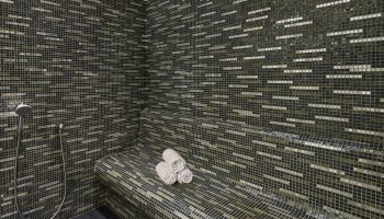 JW Marriott Hotel Istanbul Marmara Sea hamam. Mosaic tiled steam room with towels and shower. Luxury beachfront hotel near gay hamams.