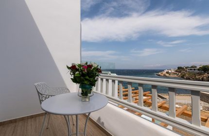 Poseidon Hotel Suites honeymoon suite balcony view in Mykonos Town. Perfect for gay honeymooners, featuring sea view and a bouquet of flowers.
