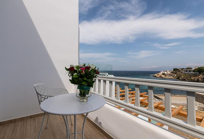 Poseidon Hotel Suites honeymoon suite balcony view in Mykonos Town. Perfect for gay honeymooners, featuring sea view and a bouquet of flowers.