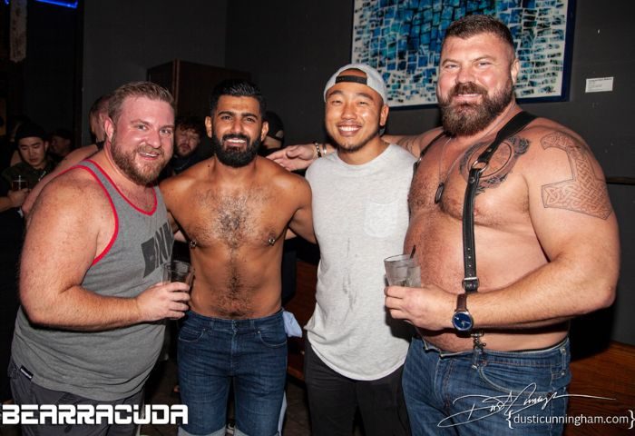 Precinct Experience: Group of gay men at a bar. Two are shirtless, one is a muscular bear. They're smiling and enjoying their time out.