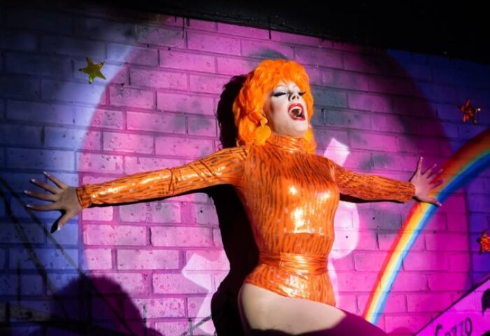 Drag queen in orange tiger-striped bodysuit performing at Pride of Footscray, Melbourne. Gay travel advice.