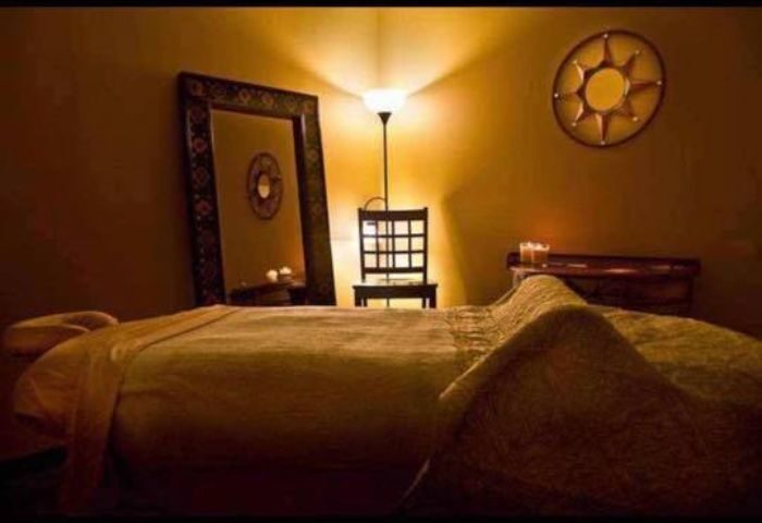 Relaxation room at Prince Men's Spa. Massage table, mirror, chair, and soft lighting create a calming atmosphere for gay men's spa treatments.