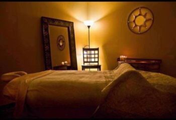 Relaxation room at Prince Men's Spa. Massage table, mirror, chair, and soft lighting create a calming atmosphere for gay men's spa treatments.