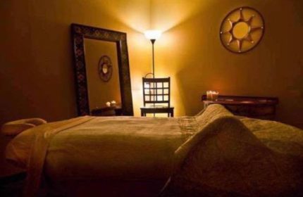 Relaxation room at Prince Men's Spa. Massage table, mirror, chair, and soft lighting create a calming atmosphere for gay men's spa treatments.