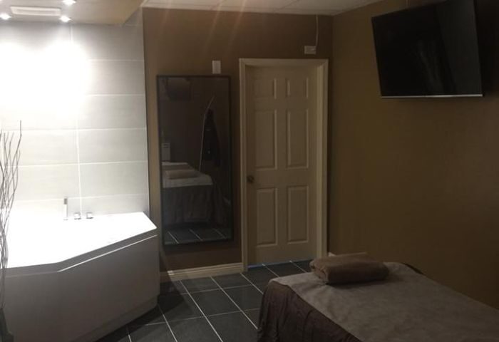 Prince Men's Spa room: A massage table, TV, and bathtub create a relaxing atmosphere. Gay men's travel guide to spa rooms.