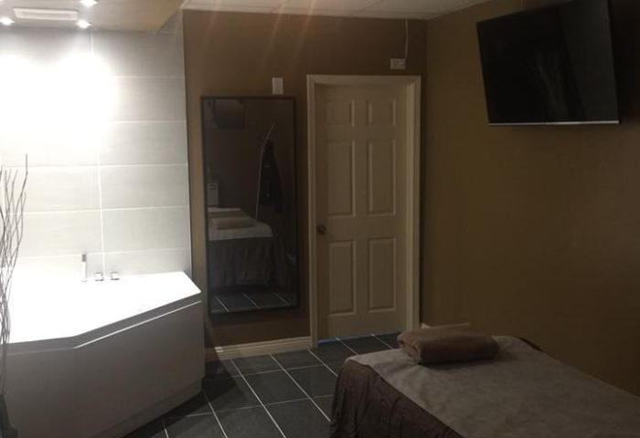 Prince Men's Spa room: A massage table, TV, and bathtub create a relaxing atmosphere. Gay men's travel guide to spa rooms.