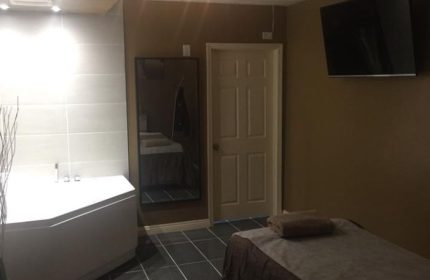 Prince Men's Spa room: A massage table, TV, and bathtub create a relaxing atmosphere. Gay men's travel guide to spa rooms.