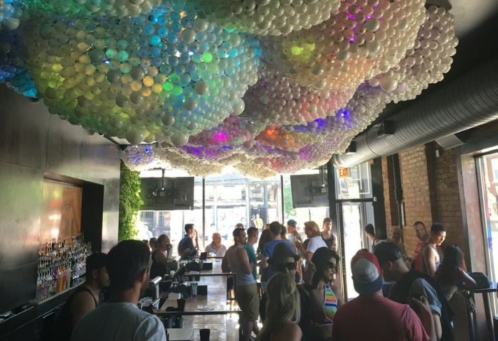 Progress Bar, a gay bar in Chicago, during party nights. A crowd gathers under a unique balloon ceiling, enjoying the vibrant atmosphere.