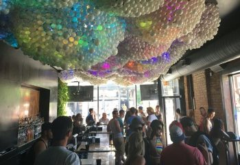 Progress Bar, a gay bar in Chicago, during party nights. A crowd gathers under a unique balloon ceiling, enjoying the vibrant atmosphere.