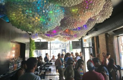 Progress Bar, a gay bar in Chicago, during party nights. A crowd gathers under a unique balloon ceiling, enjoying the vibrant atmosphere.