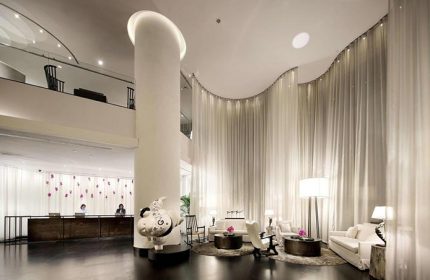 Pullman Bangkok Hotel G lobby interior. Modern design with sheer curtains, seating area, and unique art. Gay travel in Bangkok, Thailand.