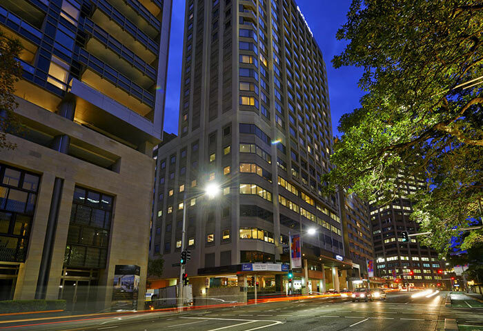 Pullman Sydney Hyde Park hotel exterior at night. Cheap luxury gay hotel in Sydney near Darlinghurst, a popular gay neighborhood.