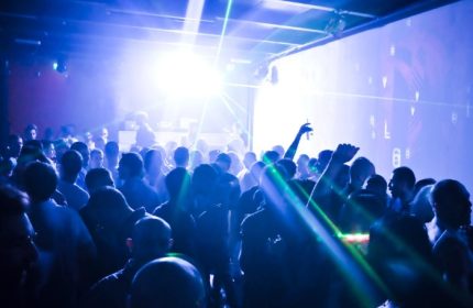 Crowd at QClub Milan, a gay dance club, enjoys music and laser lights. Gay travel advice for nightlife in Italy.