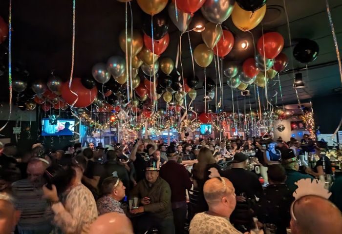 QUADZ party scene: Gay bar packed with men celebrating under balloons and lights. Travel advice for gay men. QUADZ-Party.jpg
