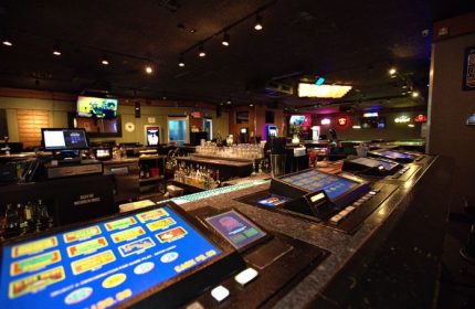 Quadz Video Bar interior in Las Vegas. Gaming machines line the bar top. This gay bar offers a fun and social atmosphere for gay men travelers.