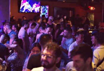 Packed Quadz Video Bar in Las Vegas. Gay bar scene with diverse crowd, tv screens, and a lively atmosphere. Gay travel destination.