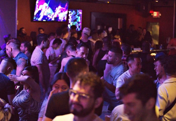 Packed Quadz Video Bar in Las Vegas. Gay bar scene with diverse crowd, tv screens, and a lively atmosphere. Gay travel destination.