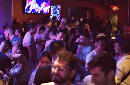 Packed Quadz Video Bar in Las Vegas. Gay bar scene with diverse crowd, tv screens, and a lively atmosphere. Gay travel destination.