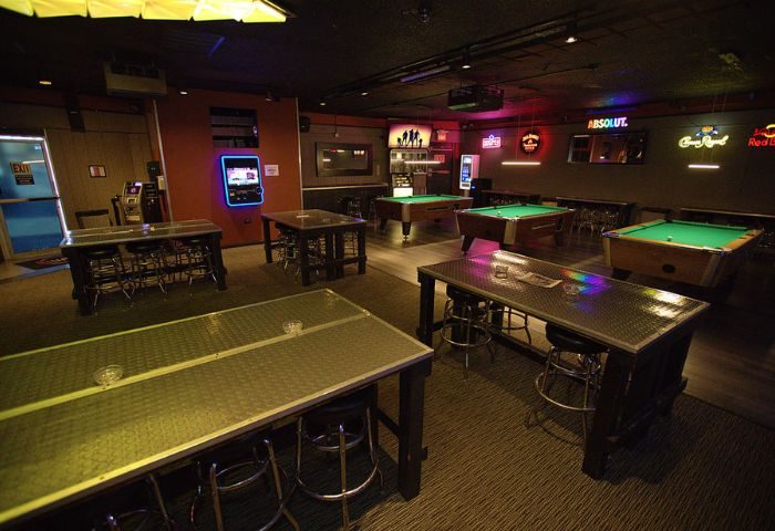 Quadz Video Bar interior, Las Vegas. Pool tables, tables with stools, and neon signs. Gay bar for men's travel advice.