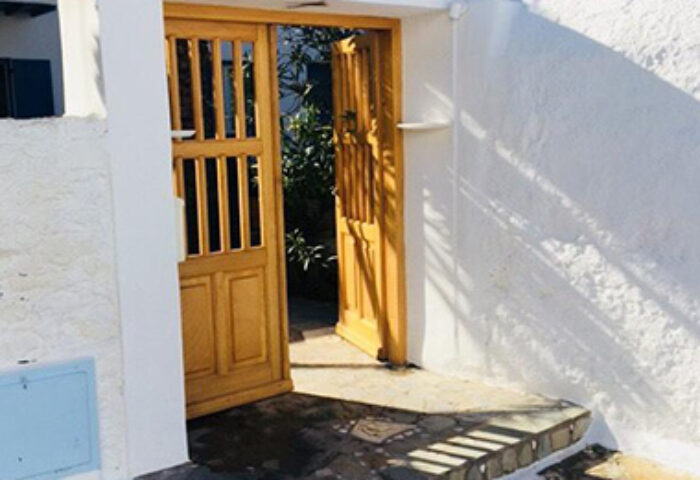 Matina Hotel entrance in Mykonos Town, near gay bars. Cheap price hotel with traditional Greek architecture. Welcoming door for gay travelers.