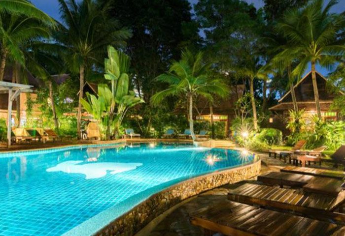 Rabbit Resort Pattaya pool view. Gay hotel near Dongtan Beach with lush tropical garden and wooden sunbeds. Cheap, relaxed vibe.