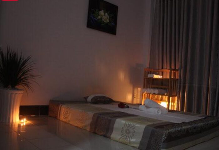 Rainbow Spa Ho Chi Minh: Massage bed with towels, candles, and flower picture. Relaxing atmosphere for gay men's travel in Vietnam.