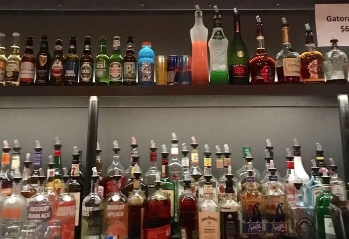 Rebar Chelsea in New York bar scene. Shelves stocked with liquor & beer bottles. A popular gay bar for drinks and nightlife in NYC.