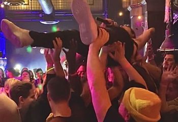 Redline Experience: Gay crowd surfing at a gay bar. Man being held up by a crowd of people, having fun, enjoying the Redline experience.