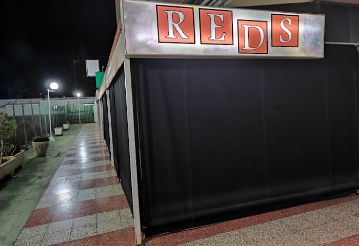 Reds Cruising Club, a gay cruise club in Gran Canaria. Exterior view of the club at night, with the REDS sign illuminated.