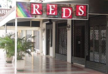 Reds Cruising Club in Gran Canaria. Gay travel destination. Club's sign with rainbow colors. Gay cruise club for men.