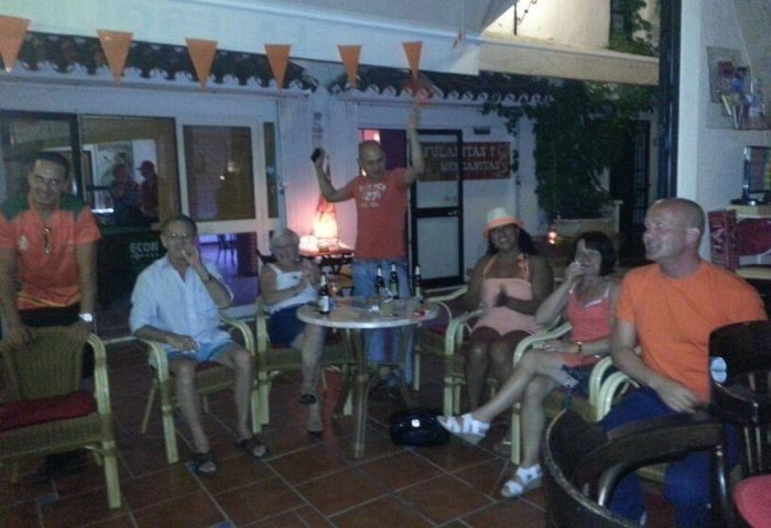 Patrons at René's Bar, La Esquina Gay Bar in Torremolinos. People sit at tables, enjoying drinks at this gay-friendly establishment.