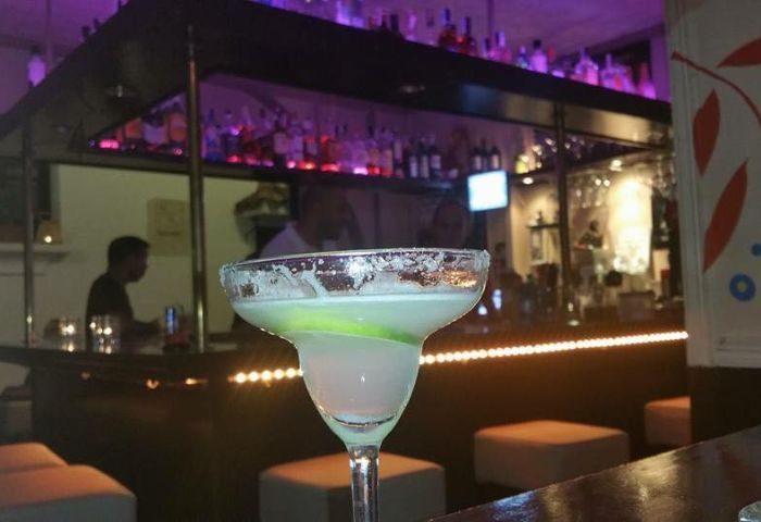 Margarita at René's Bar, a gay bar in Torremolinos, Spain. Nightlife scene with a cocktail, bar, and bottles. Gay travel destination.