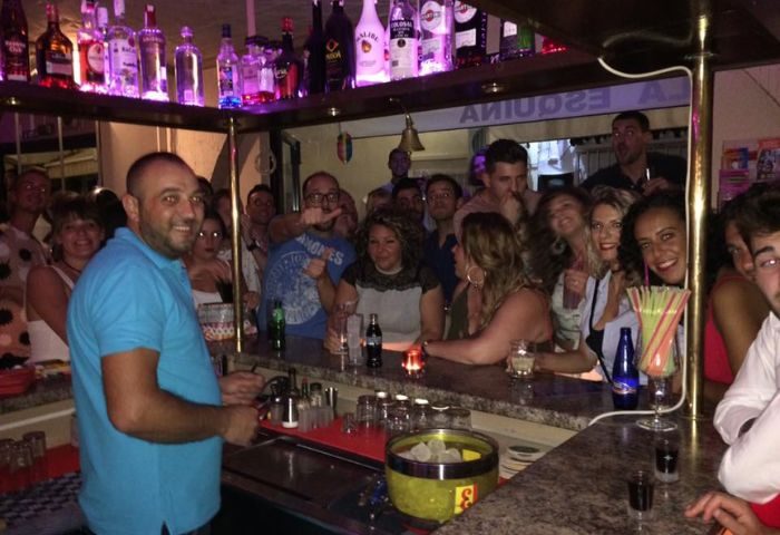 Rene's Bar, La Esquina Gay Bar in Torremolinos, Spain. A lively gay bar scene with a crowd of people enjoying drinks and socializing.