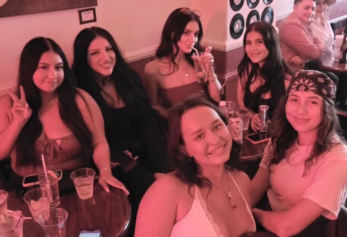 Guests at RetroRoom Lounge, a gay bar. Women smiling with drinks, enjoying the retro vibe. RetroRoom-Lounge-Guests.jpg.