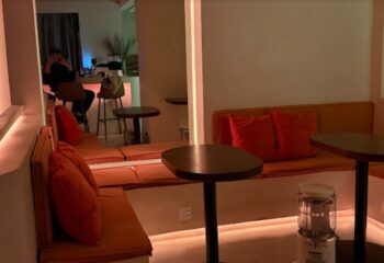 Interior of Rice Bar, Shanghai. Warm lighting, orange cushions, and small tables create a cozy atmosphere. Gay travel advice.