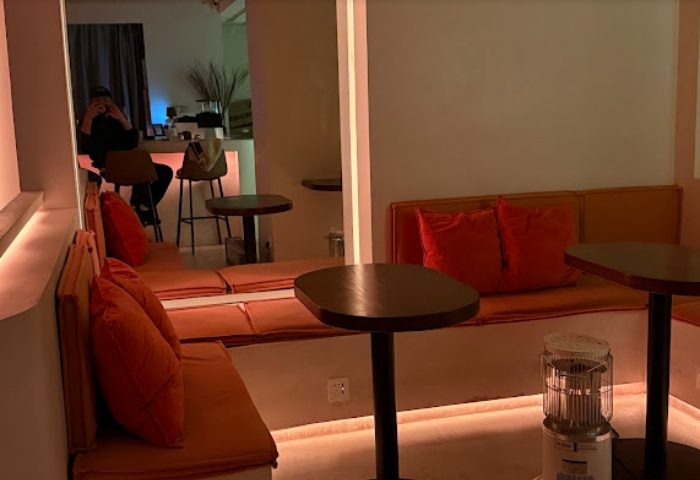Interior of Rice Bar, Shanghai. Warm lighting, orange cushions, and small tables create a cozy atmosphere. Gay travel advice.