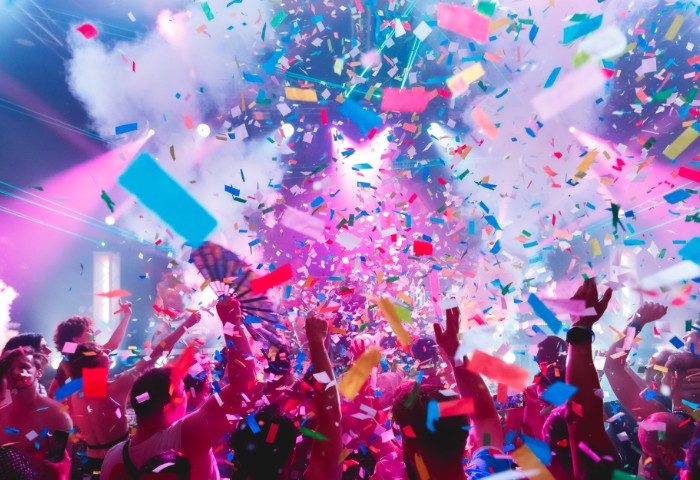 Rock City Party in Melbourne. Confetti falls on a crowd of people at a gay party, with colorful lights and smoke. Gay travel advice.