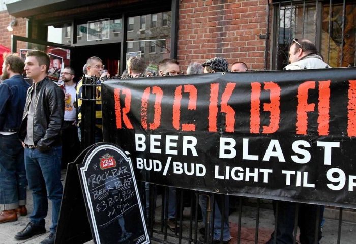 Rockbar NYC in New York: A popular gay bar with a Beer Blast promotion. Crowds gather outside, enjoying the lively atmosphere. Gay travel destination.