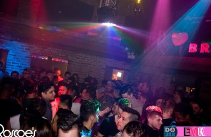 Roscoe's Tavern, a lively gay bar in Chicago. Crowd of men, colorful lights, brick walls. Nightlife scene, travel destination.