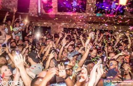 Crowd at Roscoe's Tavern, a popular gay bar in Chicago, Illinois. Confetti falling, people dancing with hands raised, phones in the air.