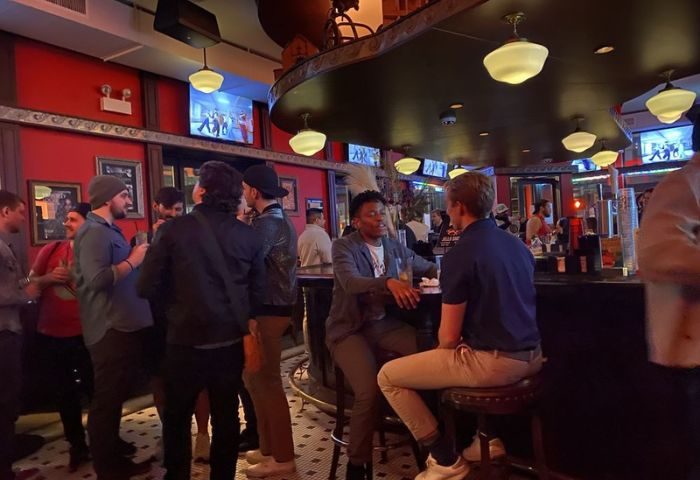 Roscoe's Tavern, a popular gay bar in Chicago. Patrons at the bar, TVs showing entertainment, and a lively social atmosphere.