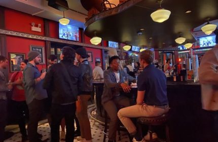 Roscoe's Tavern, a popular gay bar in Chicago. Patrons at the bar, TVs showing entertainment, and a lively social atmosphere.