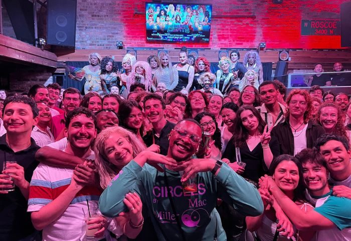 Crowd at Roscoe's Tavern, a popular gay bar in Chicago. Drag queens on stage, patrons smiling. A vibrant LGBTQ+ nightlife scene.